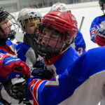 A group of athletes playing football with helmet on the field