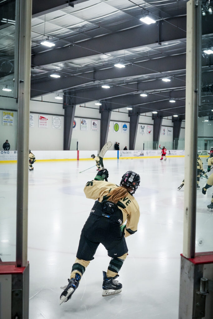 A group of athletes skating with helmet on the rink