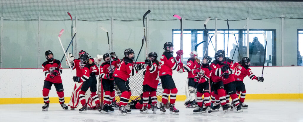 A group of athletes competing field hockey with helmet