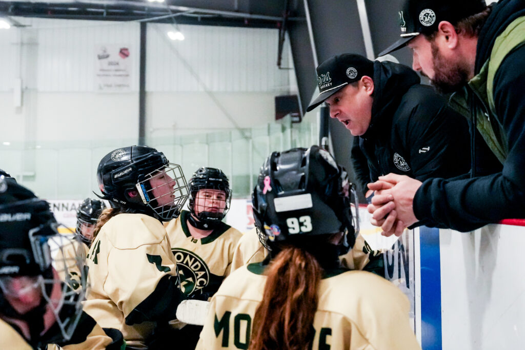 A group of athletes playing football with helmet on the field