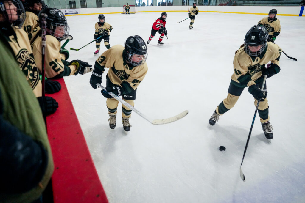 A group of athletes skating with helmet on the rink