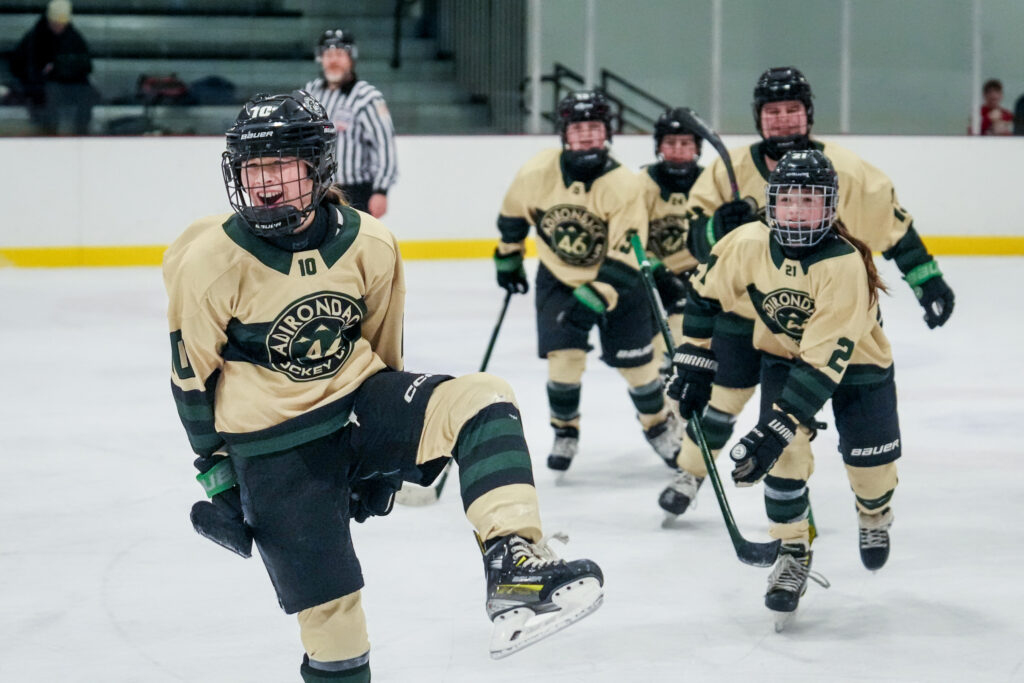 A group of athletes competing field hockey with helmet
