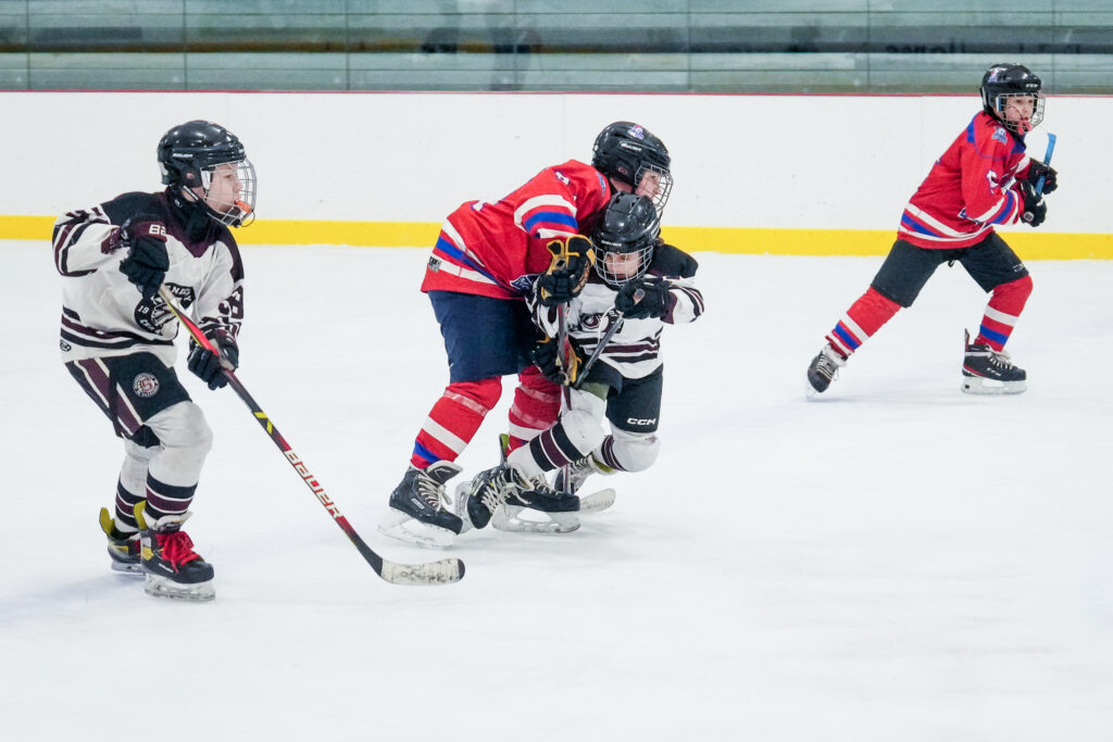 A group of athletes competing field hockey with helmet