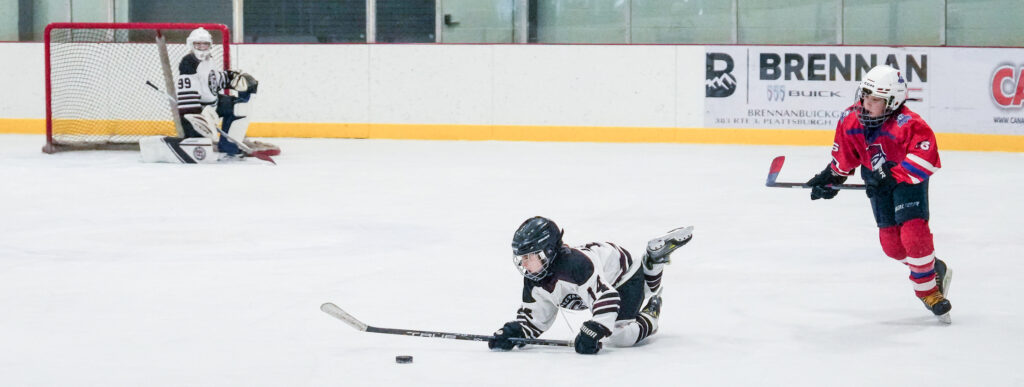 A group of athletes competing field hockey with helmet
