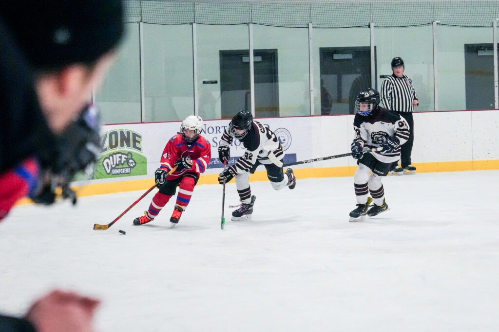 A group of athletes competing field hockey with helmet