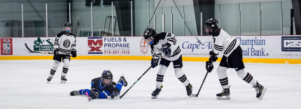 A group of athletes competing field hockey with helmet