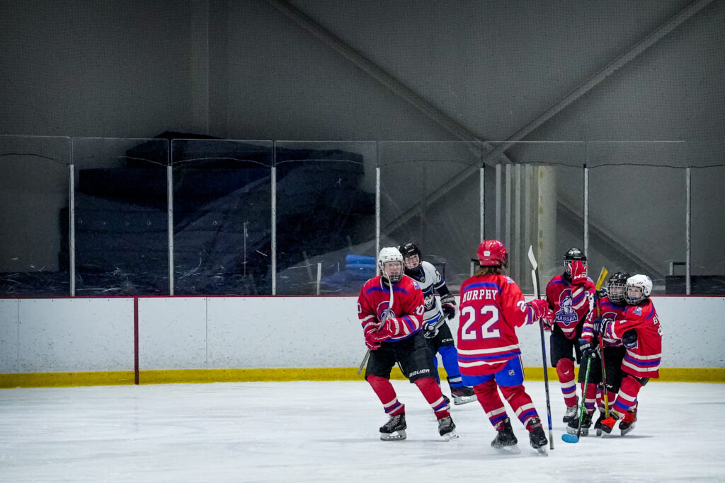 A group of athletes skating with helmet on the rink