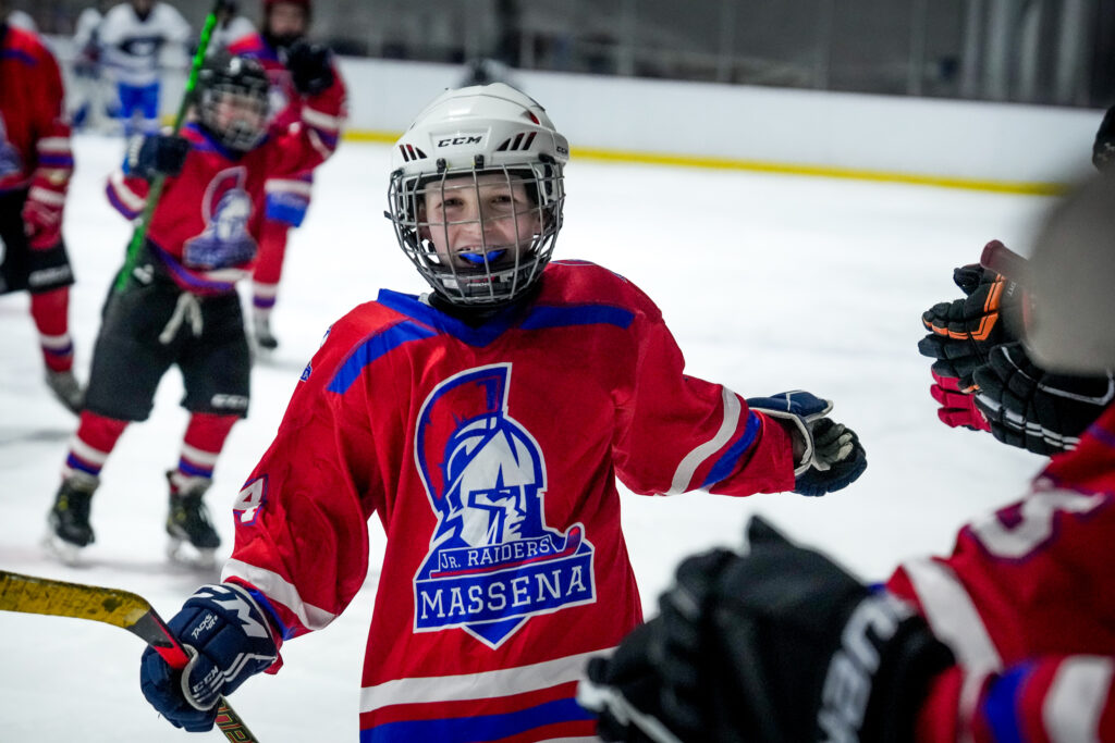 A group of athletes competing field hockey with helmet