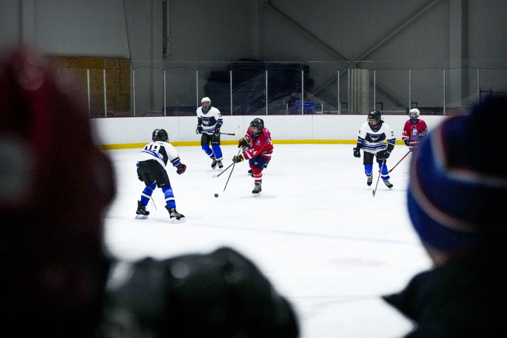 A group of athletes skating with helmet on the rink
