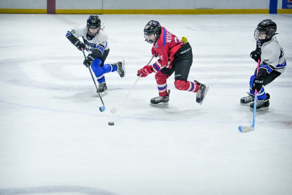 A group of athletes skating with helmet on the rink
