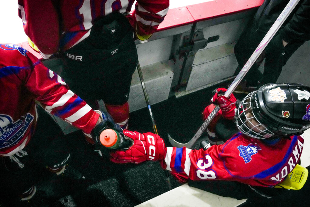Two athletes skating with helmet on the rink