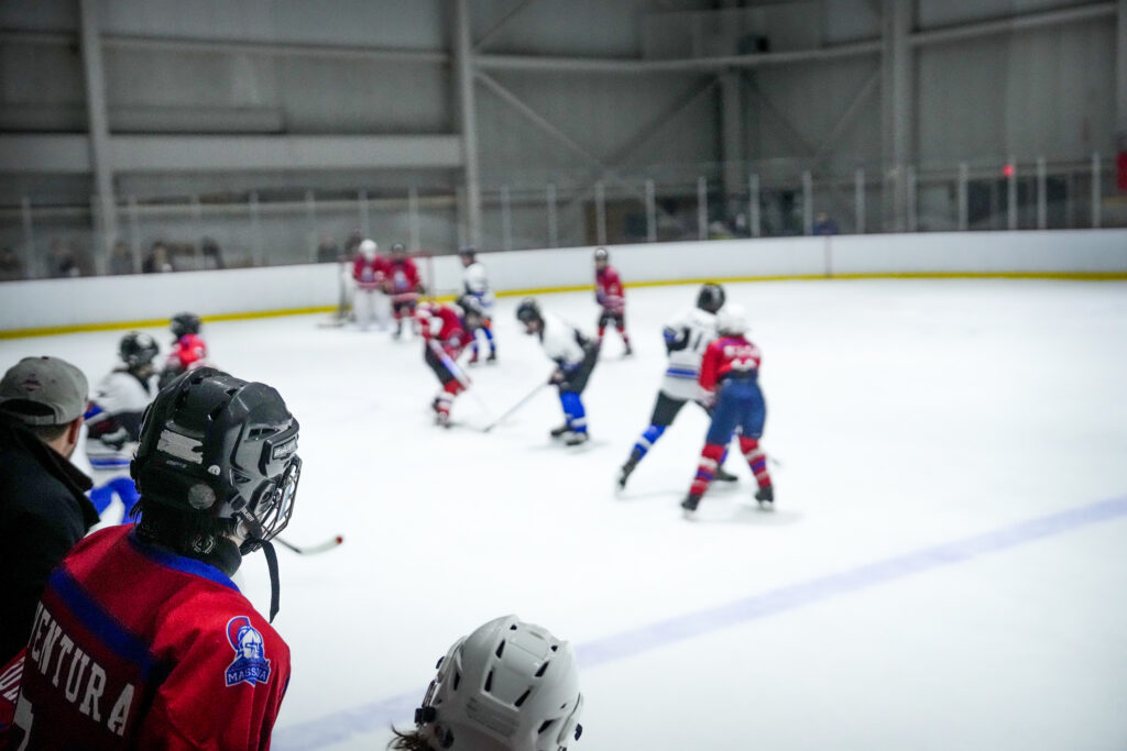 A group of athletes skating with helmet on the rink