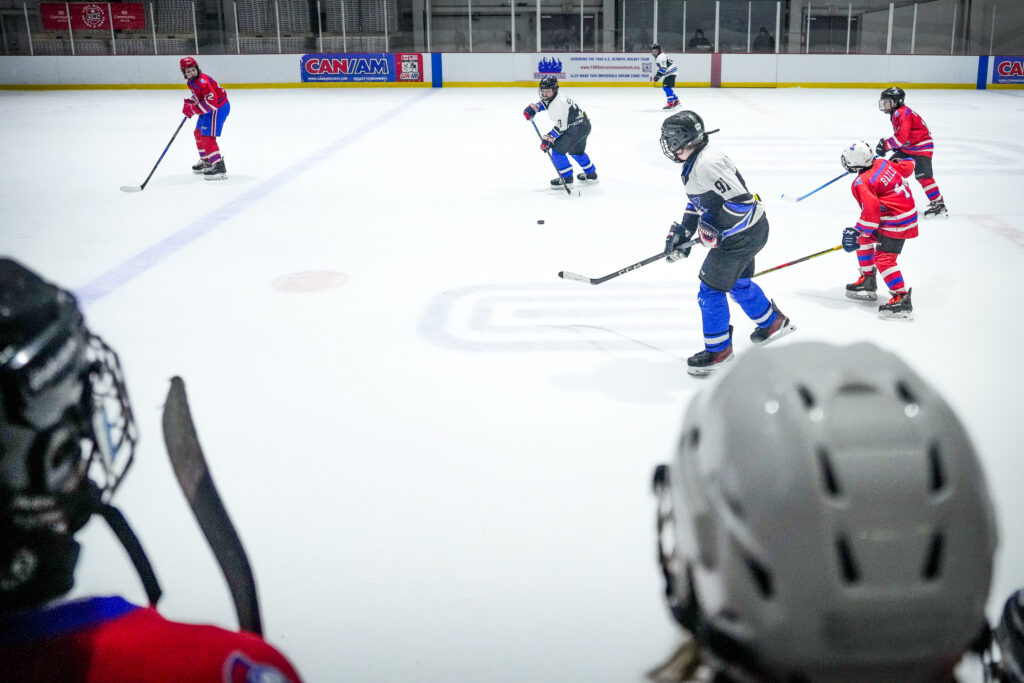 A group of athletes skating with helmet on the rink