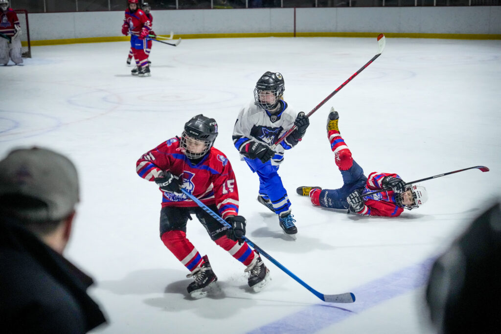 A group of athletes skating with helmet on the rink