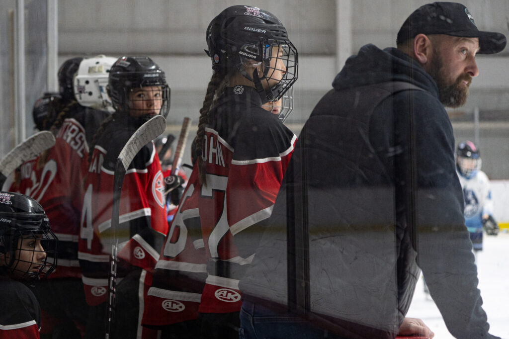 A group of athletes competing field hockey with helmet