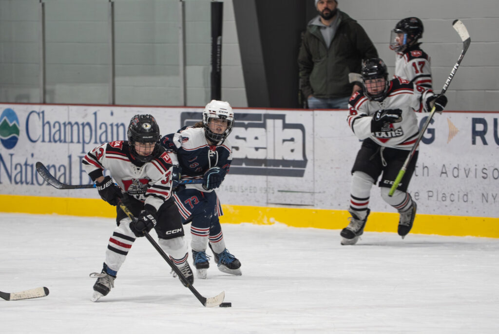 A group of athletes competing field hockey with helmet