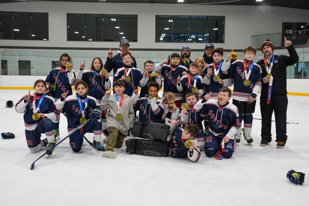 A group of athletes competing field hockey with helmet