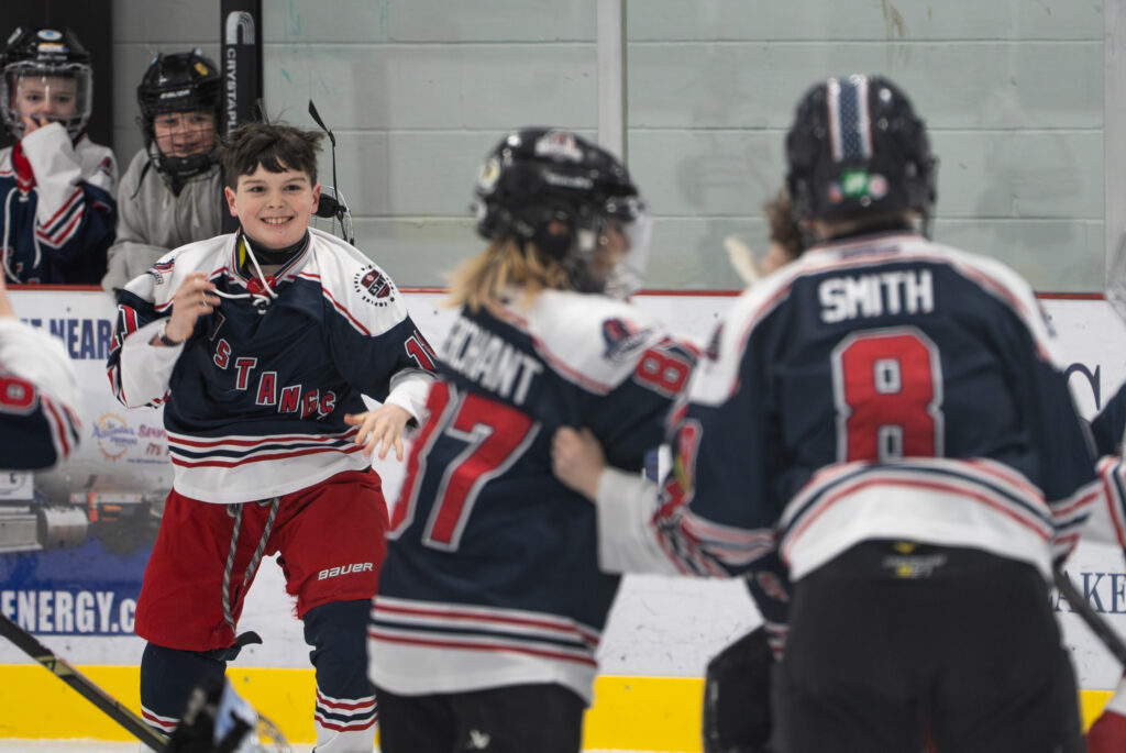 A group of athletes competing field hockey with helmet