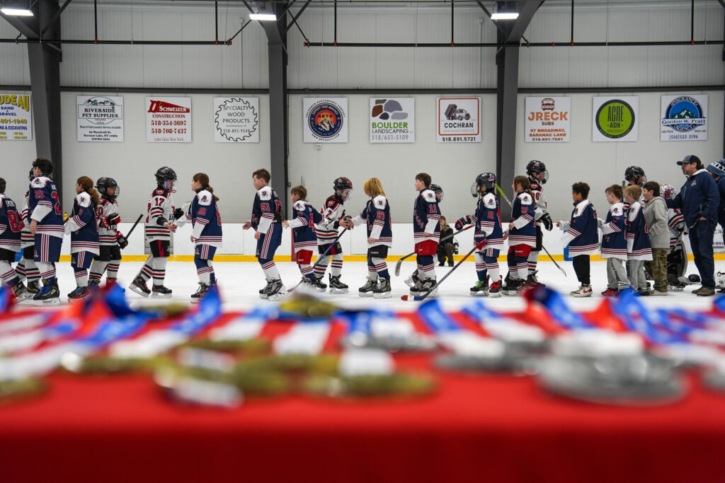 A group of athletes competing field hockey with helmet