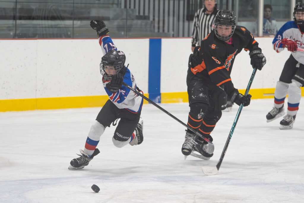 A group of athletes competing field hockey with helmet