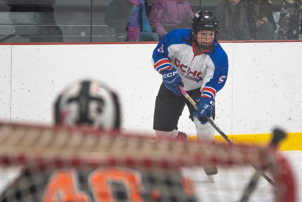 A group of athletes playing soccer with ball and helmet on the field