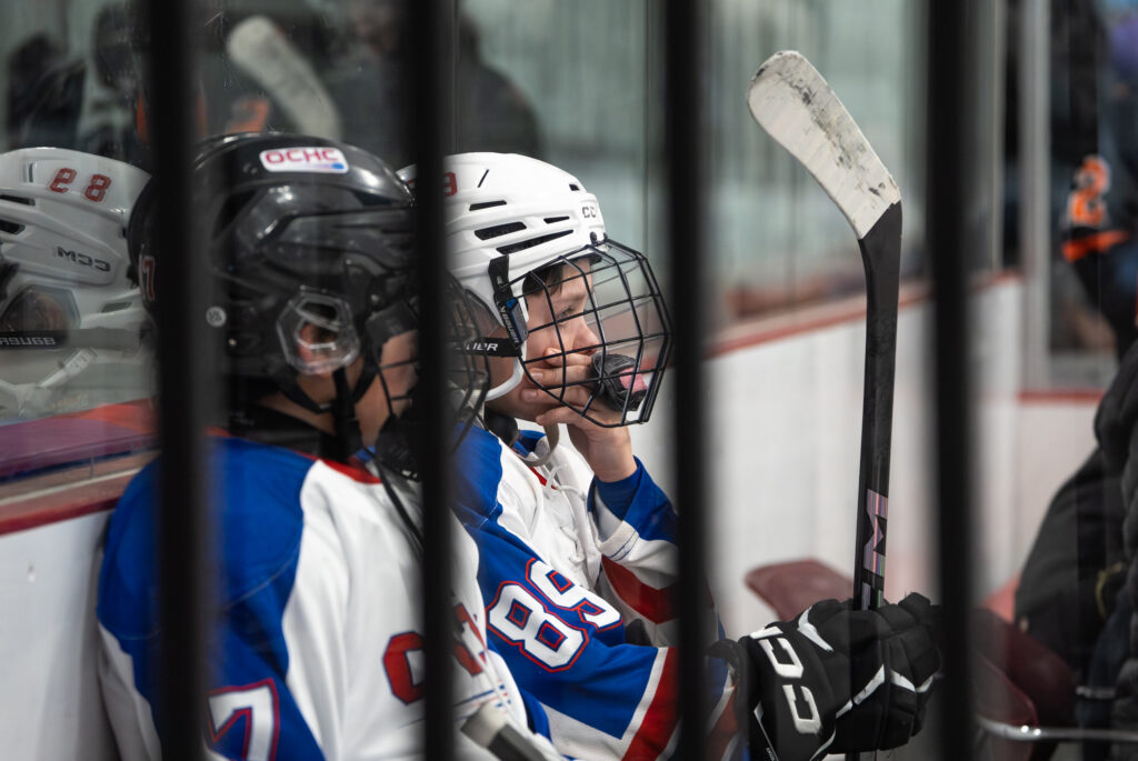 Two athletes skating with helmet on the rink