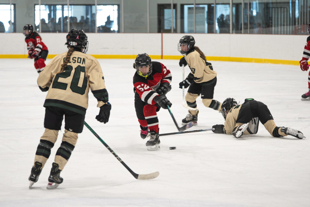 A group of athletes skating with helmet on the rink