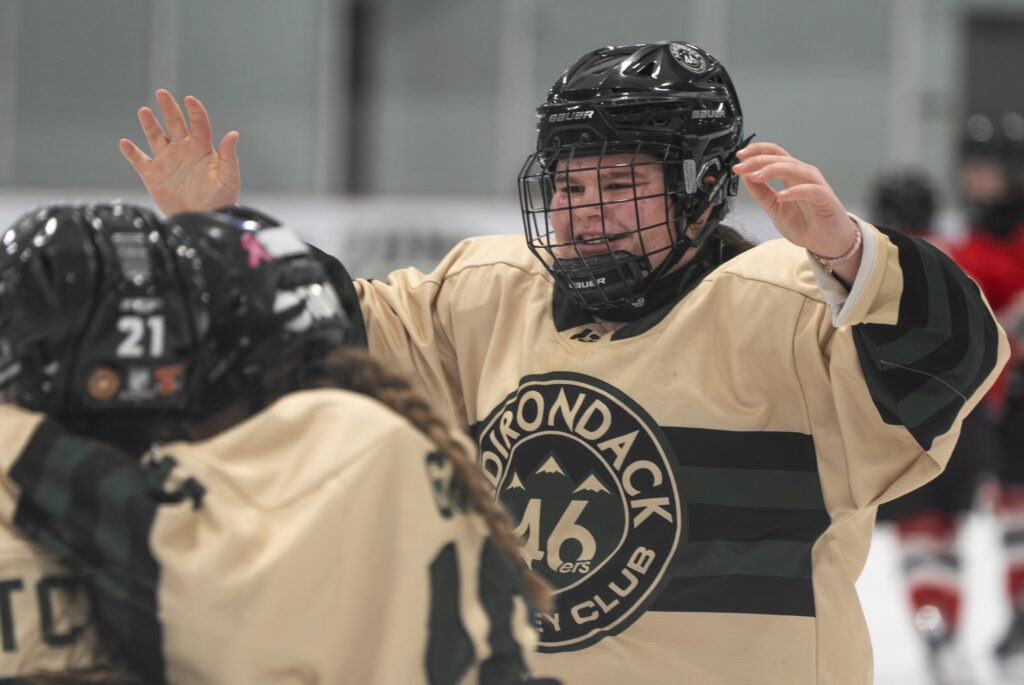 Two athletes playing football with helmet on the field