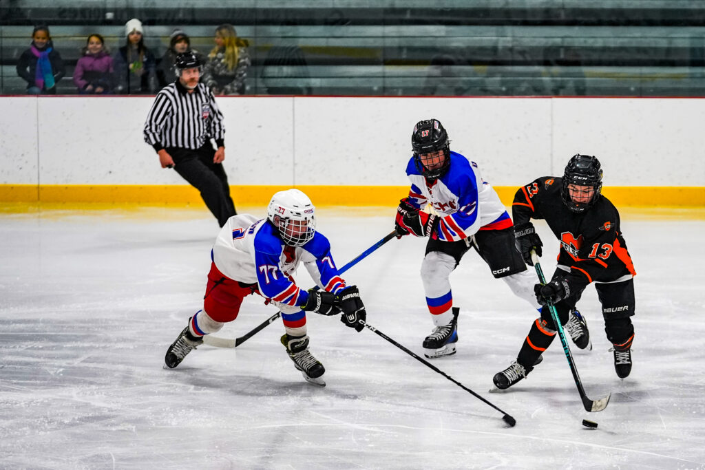 A group of athletes skating with helmet on the rink