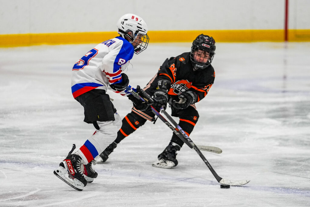Two athletes skating with helmet on the rink