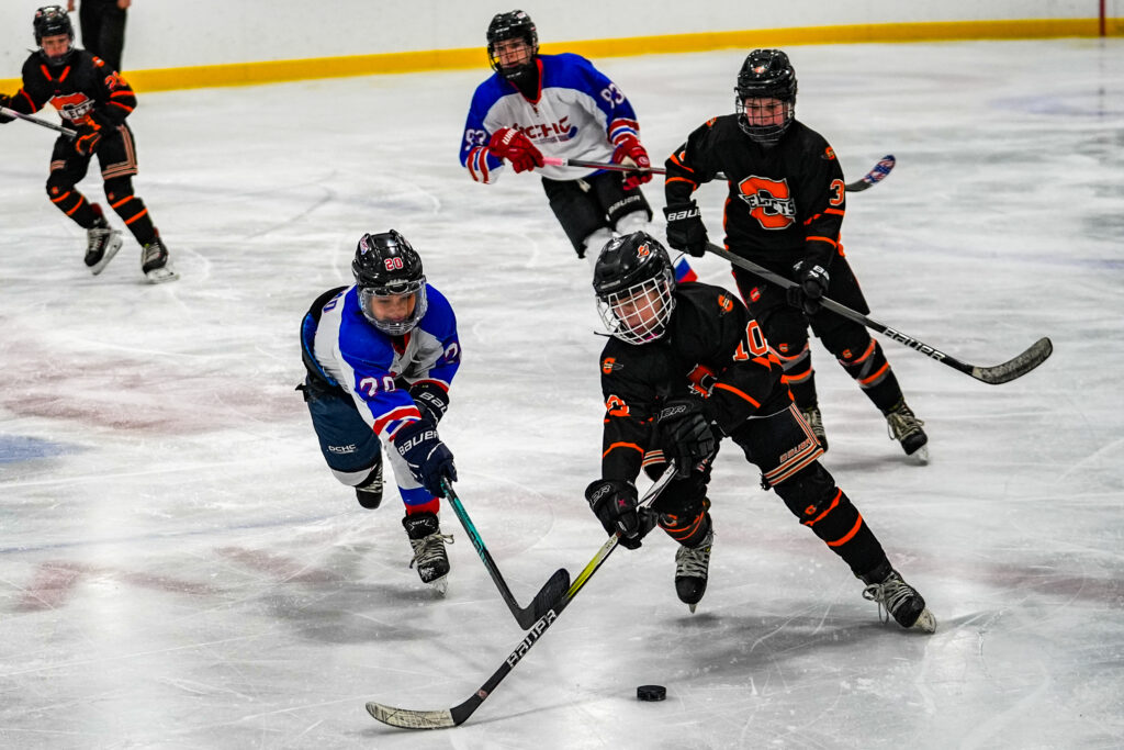 A group of athletes skating with helmet on the rink