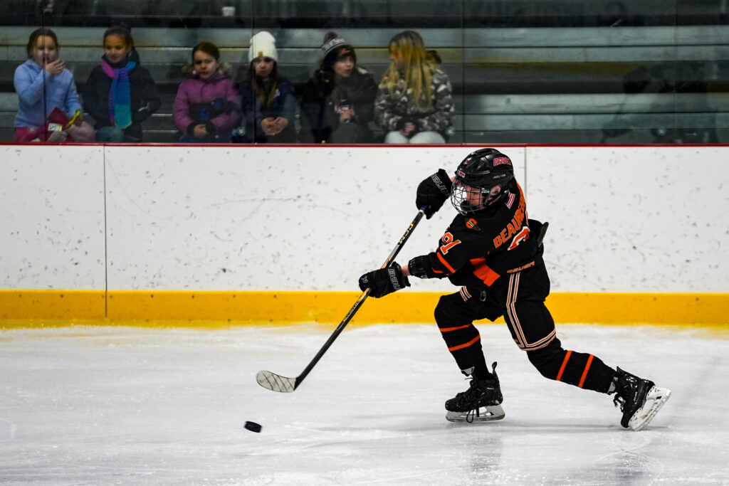 A group of athletes skating with helmet on the rink