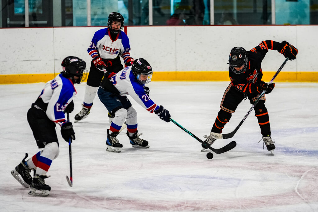 A group of athletes skating with helmet on the rink