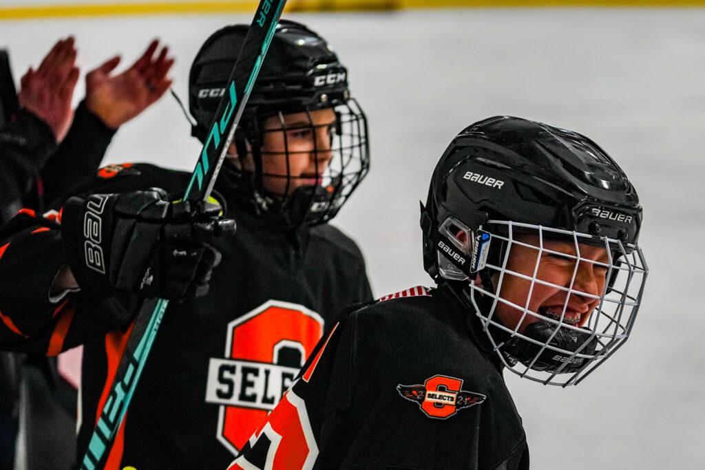 Two athletes skating with helmet on the rink