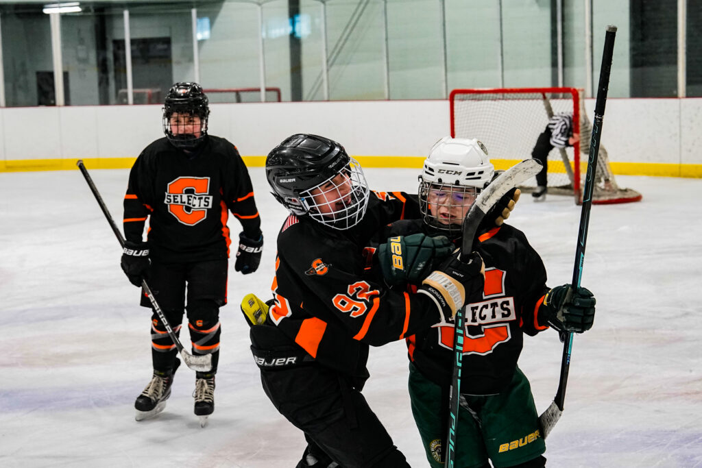 Two athletes skating with helmet on the rink