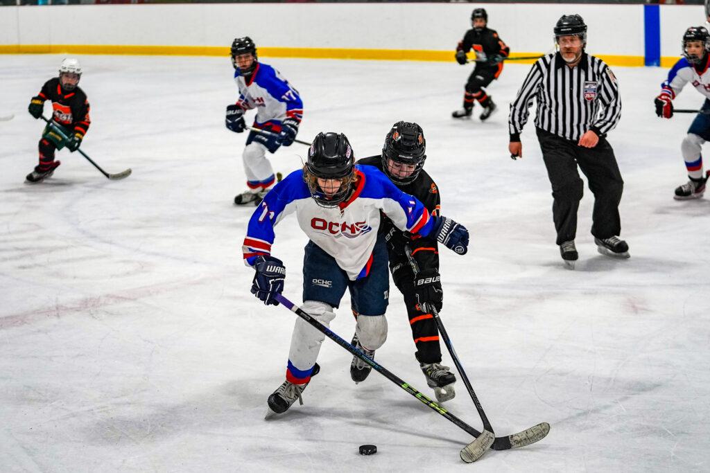 A group of athletes skating with helmet on the rink