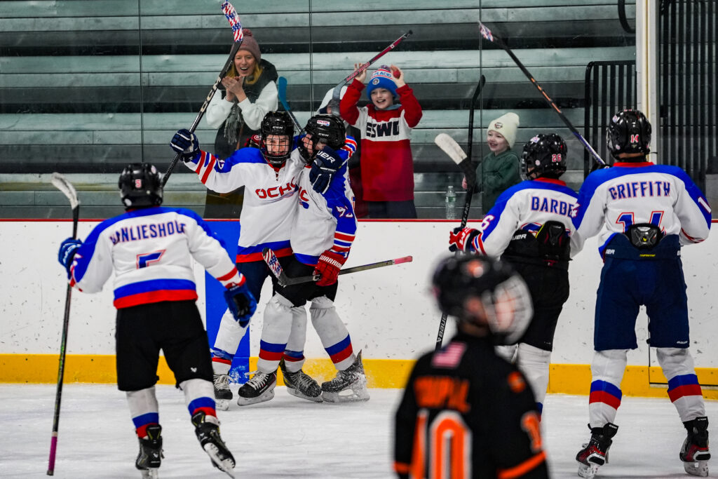 A group of athletes skating with helmet on the rink