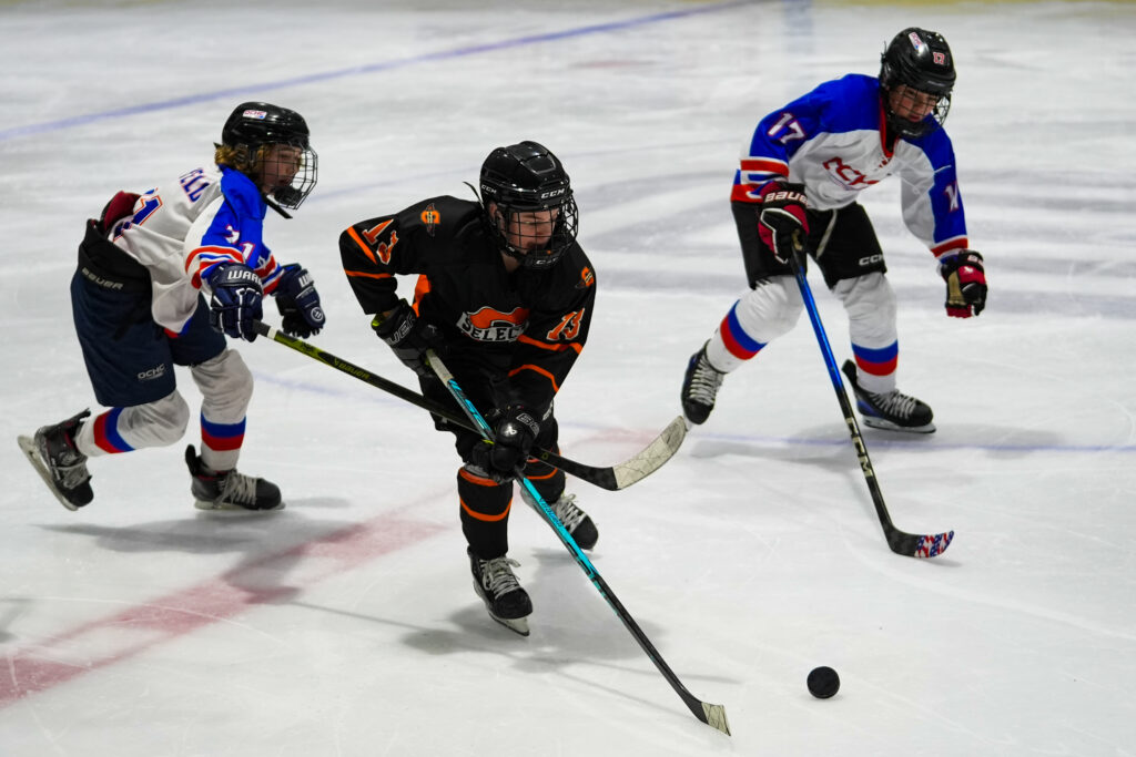A group of athletes skating with helmet on the rink