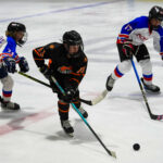 A group of athletes skating with helmet on the rink