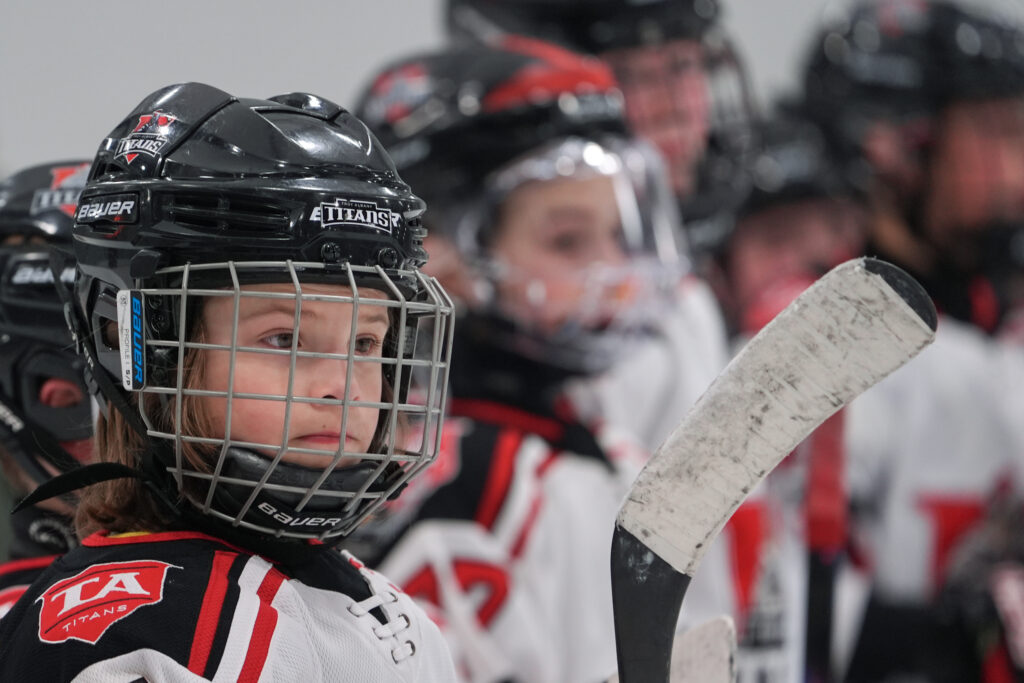 Two athletes playing football with helmet on the field