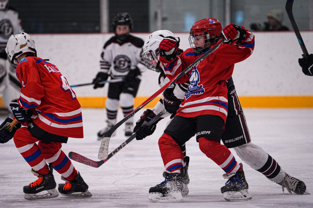 A group of athletes competing field hockey with helmet