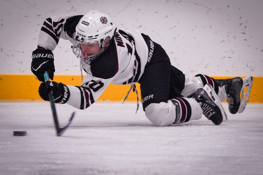 An athlete skating with helmet on the rink