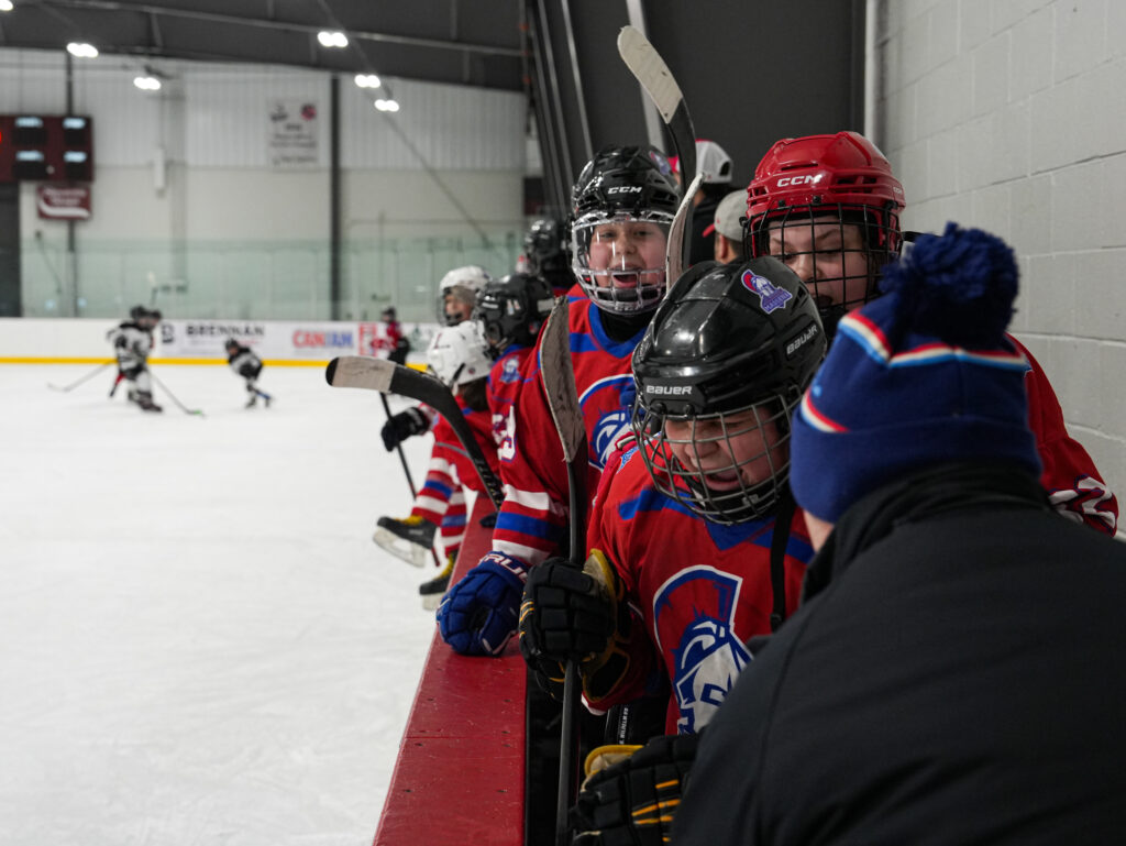 A group of athletes competing field hockey with helmet