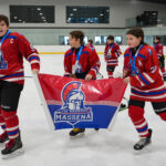 A group of athletes competing field hockey