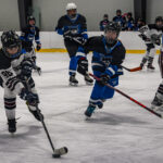 A group of athletes competing field hockey with helmet