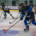 A group of athletes skating with helmet on the rink
