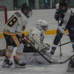 A group of athletes competing field hockey with helmet