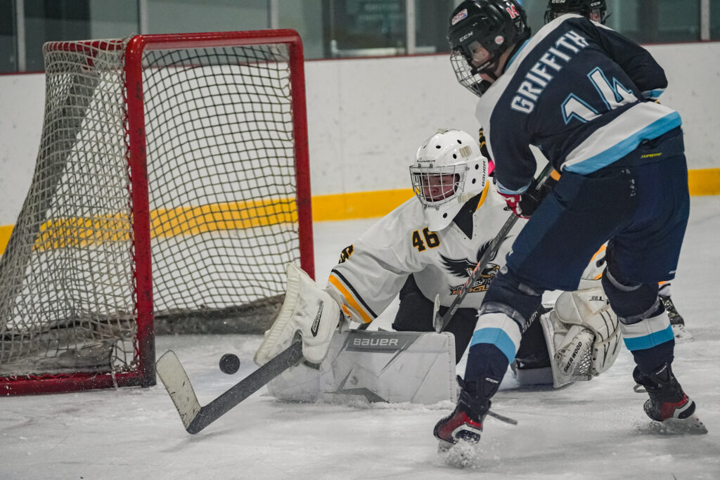 Two athletes skating with helmet on the rink
