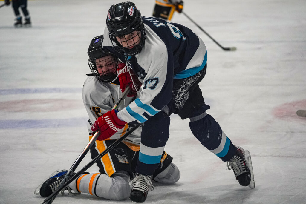 A group of athletes competing field hockey with helmet