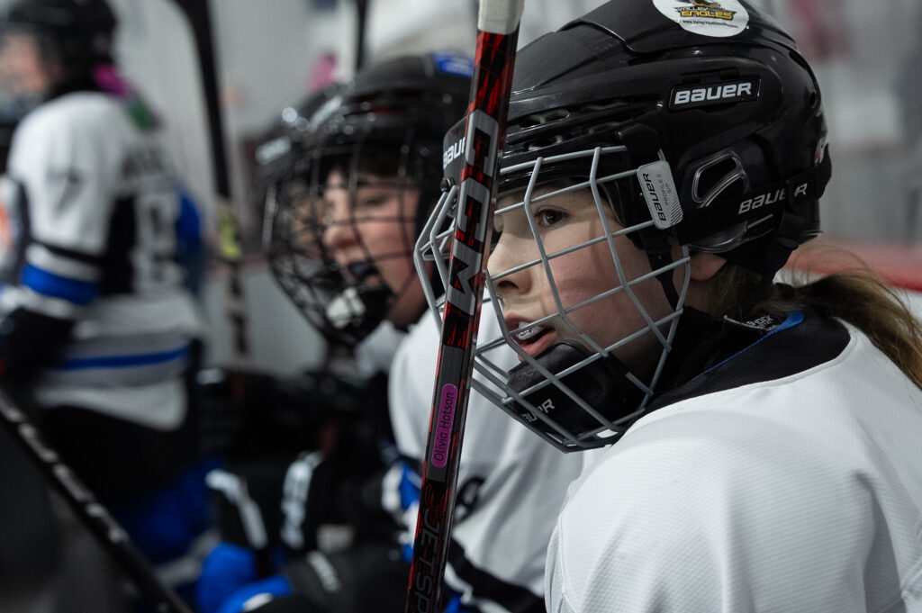 A group of athletes competing field hockey with helmet